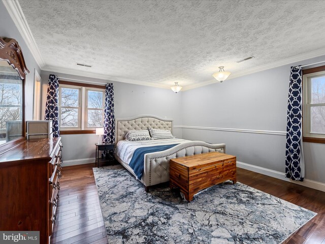 bedroom with dark hardwood / wood-style floors, ornamental molding, and a textured ceiling