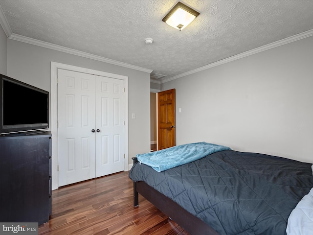 bedroom featuring crown molding, a closet, dark wood-type flooring, and a textured ceiling