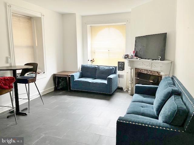 living room featuring a fireplace and radiator heating unit