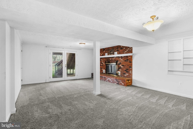 unfurnished living room with carpet flooring, a textured ceiling, and a wood stove