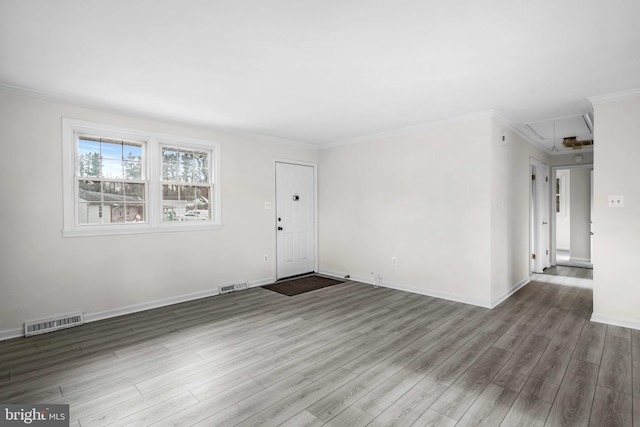 spare room featuring wood-type flooring and crown molding