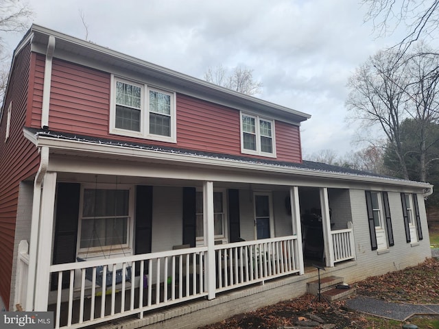 view of front of property featuring brick siding and covered porch