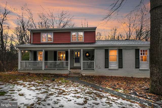 view of front facade with brick siding and covered porch