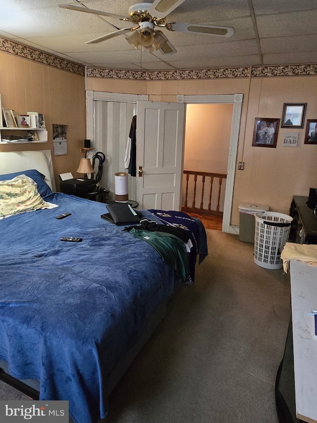 bedroom featuring carpet flooring, ceiling fan, and a drop ceiling