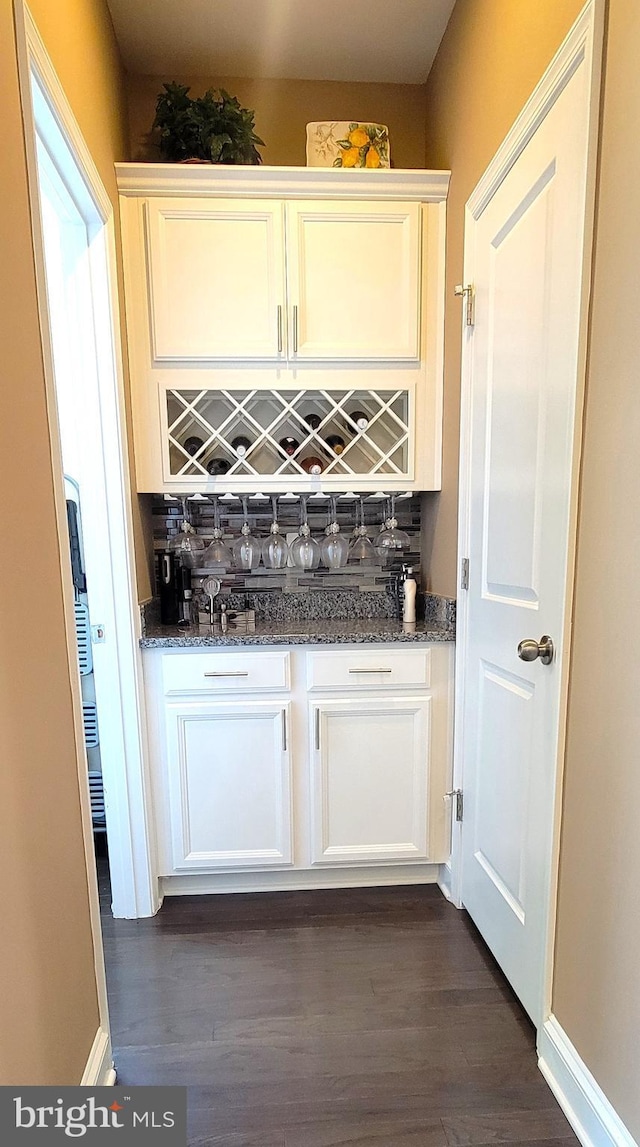 bar featuring white cabinets and dark wood-type flooring