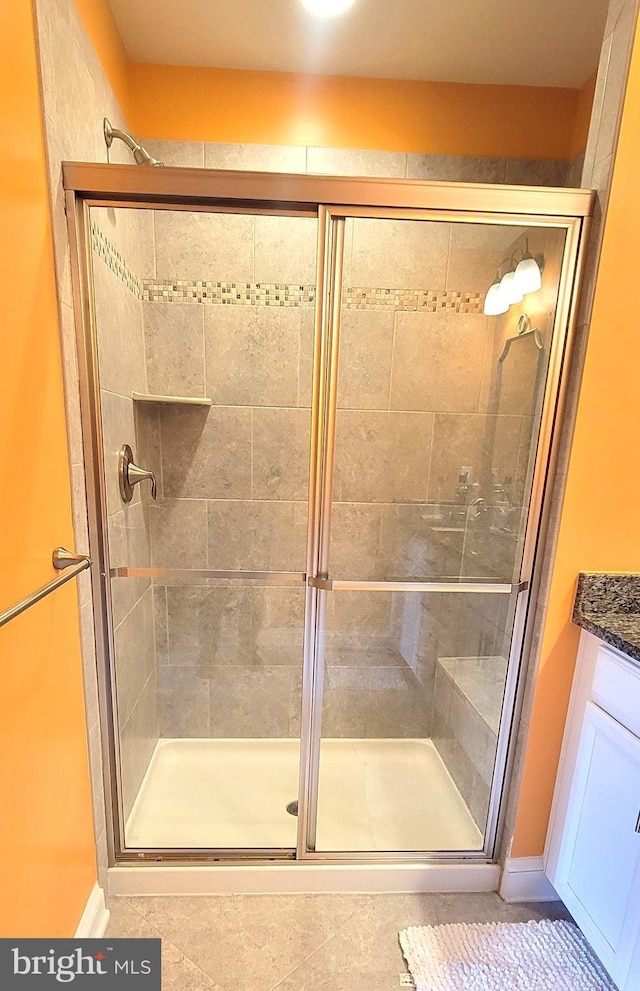 bathroom featuring tile patterned floors, vanity, and a shower with shower door