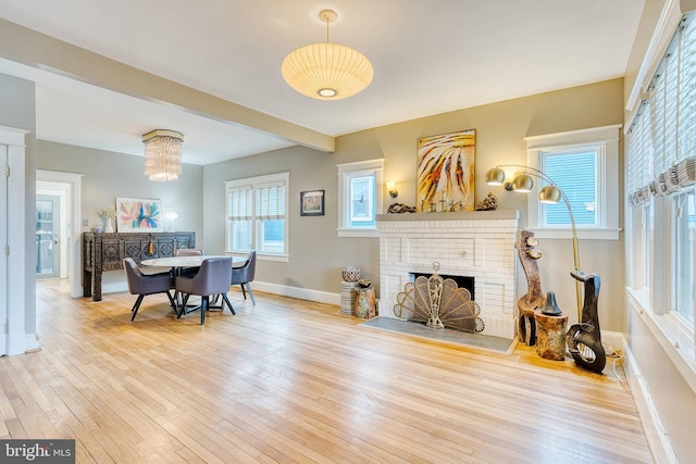 living room featuring hardwood / wood-style floors, a wealth of natural light, and a brick fireplace