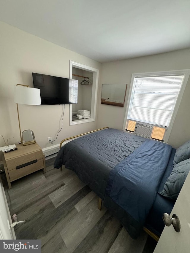 bedroom with cooling unit and dark wood-type flooring