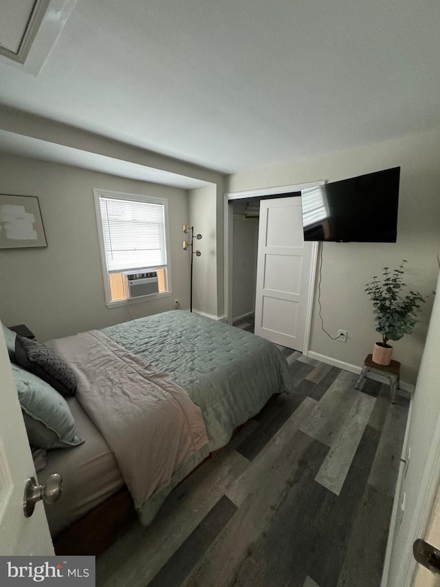 bedroom with dark hardwood / wood-style flooring and a closet