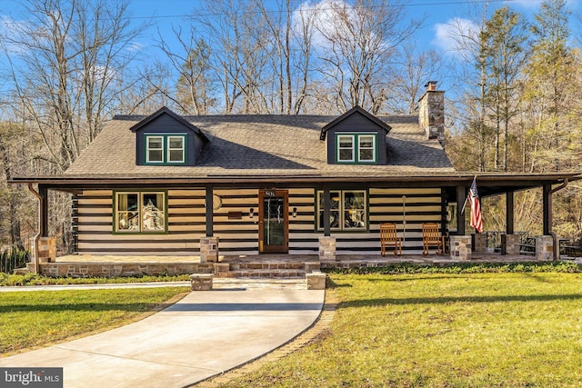 log cabin featuring a front lawn, a porch, a chimney, and a shingled roof