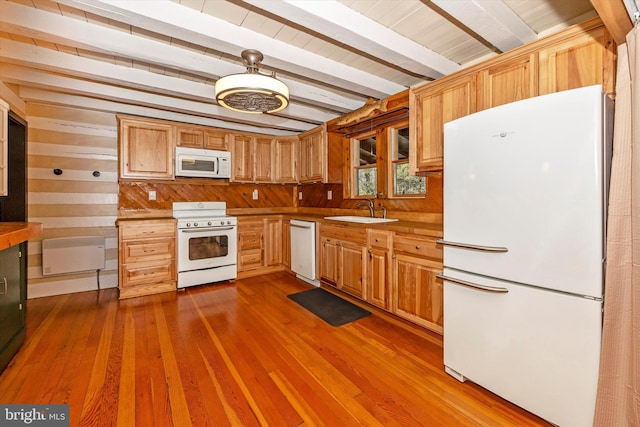 kitchen featuring sink, dark wood-type flooring, beamed ceiling, white appliances, and wooden walls