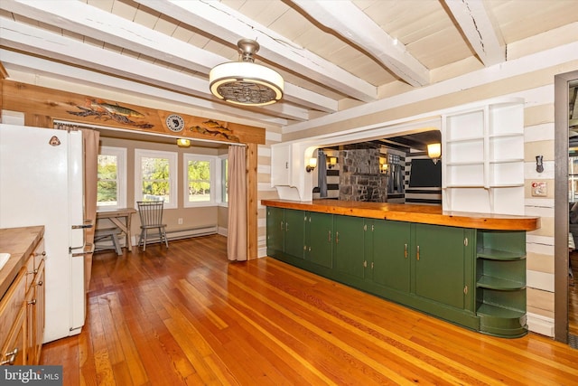 kitchen featuring wood-type flooring, white fridge, green cabinetry, and butcher block counters