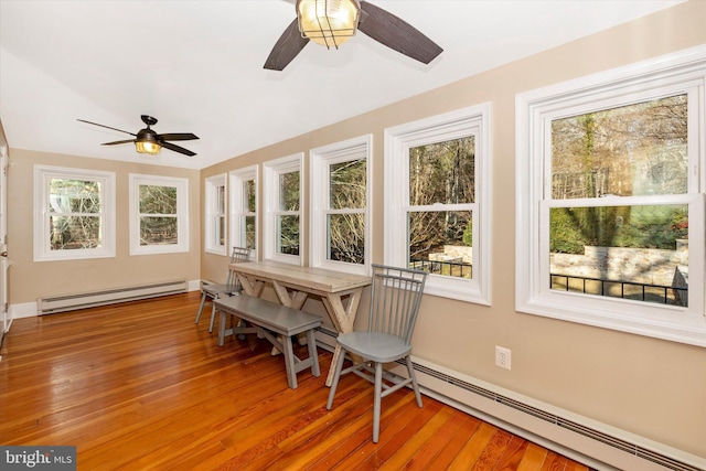 sunroom featuring ceiling fan and a baseboard heating unit