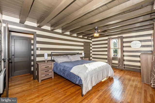 bedroom with beamed ceiling, ceiling fan, and dark hardwood / wood-style flooring