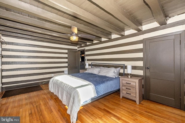 bedroom with ceiling fan, beam ceiling, light wood-type flooring, and wooden ceiling