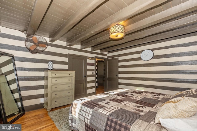 bedroom with beamed ceiling and light wood-type flooring