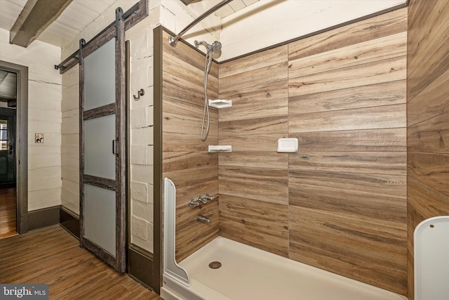 bathroom with beamed ceiling, wood walls, a shower, and wood-type flooring