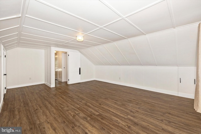 additional living space with dark hardwood / wood-style flooring and vaulted ceiling