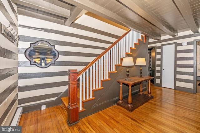 stairs featuring beam ceiling, hardwood / wood-style floors, and wood ceiling