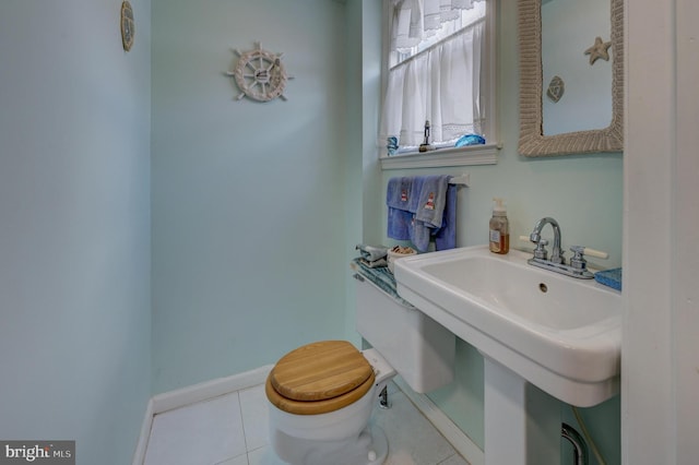 bathroom featuring toilet, tile patterned floors, and sink