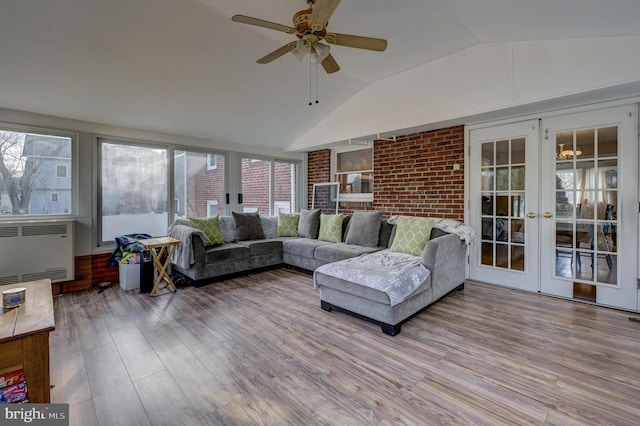 sunroom featuring radiator, ceiling fan, french doors, and vaulted ceiling