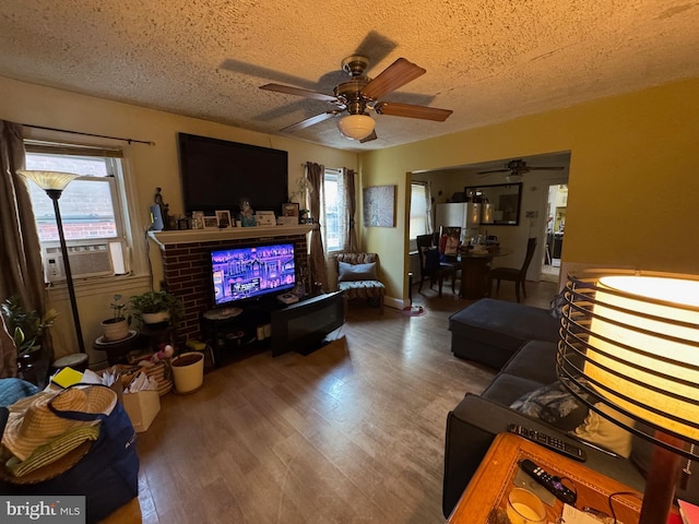 living room with ceiling fan, a textured ceiling, hardwood / wood-style floors, and cooling unit