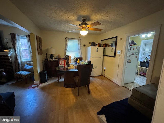 dining space featuring ceiling fan, a textured ceiling, and hardwood / wood-style floors