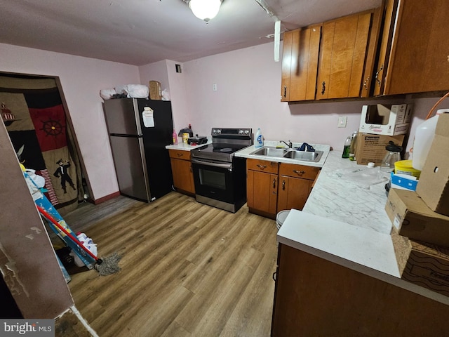 kitchen featuring stainless steel appliances, light hardwood / wood-style flooring, and sink