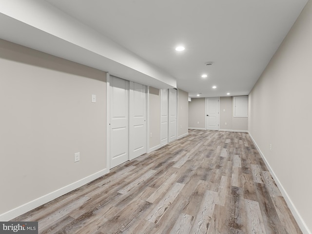 basement with light hardwood / wood-style flooring