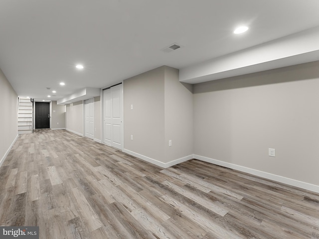 basement with light hardwood / wood-style floors