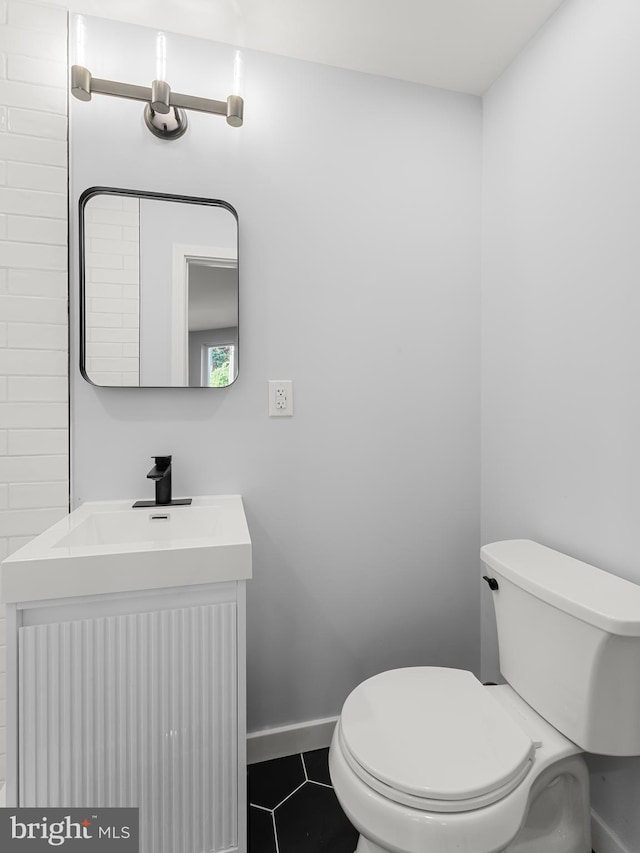 bathroom with tile patterned flooring, vanity, and toilet