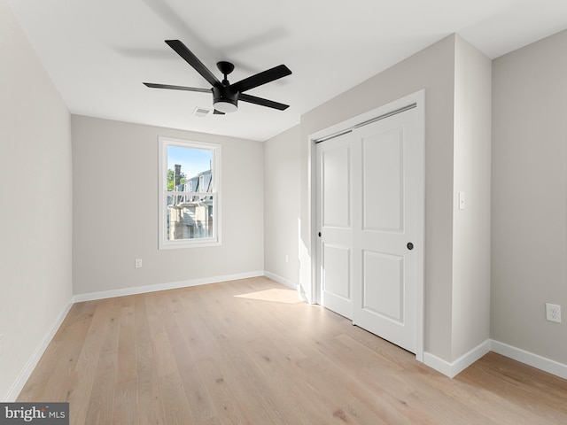 unfurnished bedroom with ceiling fan, a closet, and light hardwood / wood-style flooring