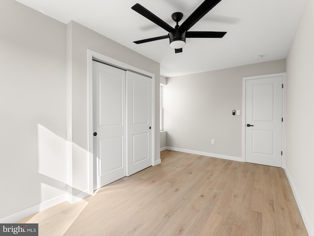 unfurnished bedroom with a closet, light hardwood / wood-style floors, and ceiling fan