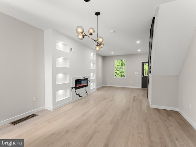 unfurnished living room with a notable chandelier and light wood-type flooring