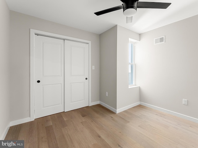 unfurnished bedroom with ceiling fan, light hardwood / wood-style floors, and a closet