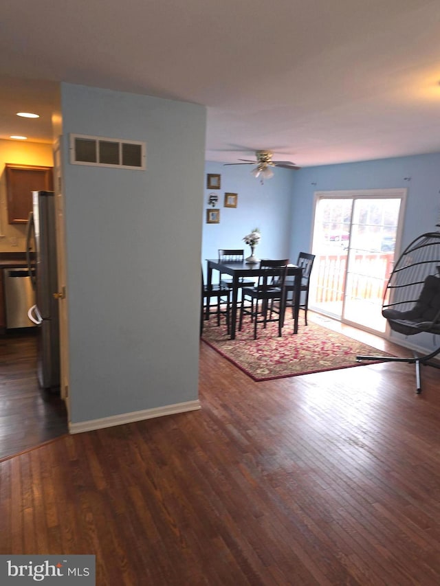 dining space with ceiling fan and dark wood-type flooring