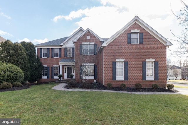 view of front of home with brick siding and a front yard