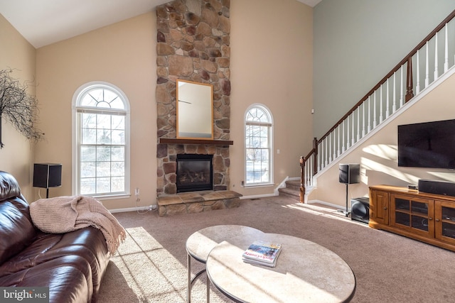 living room featuring carpet flooring, a stone fireplace, plenty of natural light, and high vaulted ceiling