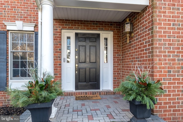 property entrance featuring brick siding