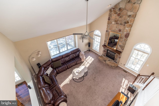 carpeted living room with a fireplace, high vaulted ceiling, ceiling fan, and plenty of natural light