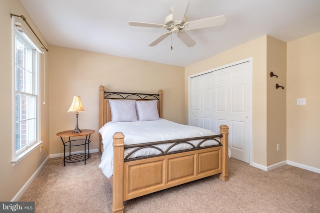 bedroom with light colored carpet, a closet, and ceiling fan