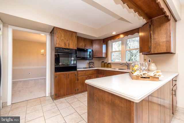 kitchen with kitchen peninsula, sink, light tile patterned floors, and black appliances