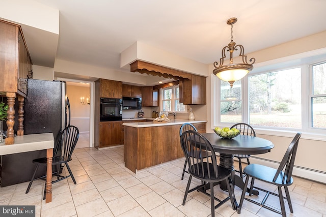 kitchen featuring kitchen peninsula, pendant lighting, light tile patterned floors, and black appliances