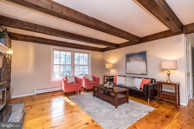 living room with baseboard heating, a stone fireplace, beamed ceiling, and light wood-type flooring