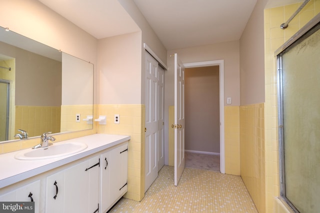 bathroom with tile patterned floors, vanity, and tile walls