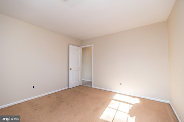 unfurnished room featuring light carpet