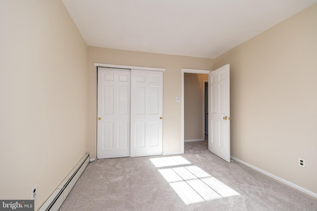 unfurnished bedroom featuring light colored carpet, a closet, and a baseboard heating unit