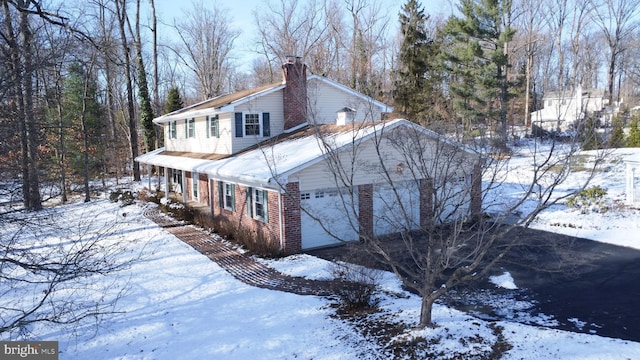 view of snow covered exterior featuring a garage