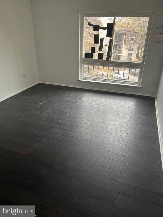 unfurnished room with dark hardwood / wood-style floors and plenty of natural light