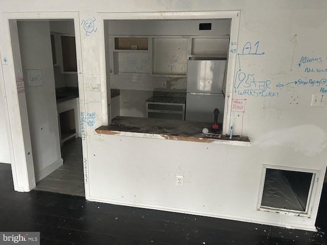 kitchen with dark hardwood / wood-style floors and stainless steel refrigerator